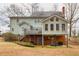 Exterior rear view featuring a brick foundation, a wooden porch with a deck, and a grassy yard at 3521 Southern Bay Ct, Snellville, GA 30039