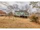 Wide shot of the backyard with a swing set and patio, on a property with many trees at 3521 Southern Bay Ct, Snellville, GA 30039