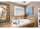 Bathroom with corner soaking tub, tiled backsplash, and decorative artwork at 3521 Southern Bay Ct, Snellville, GA 30039