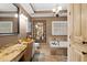 Bathroom featuring granite vanity, soaking tub, and a decorative mirror at 3521 Southern Bay Ct, Snellville, GA 30039
