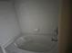White tiled bathroom with a large bathtub and chrome fixtures at 11329 Michelle Way, Hampton, GA 30228