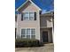 Tan home with black shutters, black screen door, and manicured landscaping at 11329 Michelle Way, Hampton, GA 30228