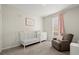 Bedroom featuring a crib, dresser, comfortable chair, and natural light at 305 Thorntree Ln, Canton, GA 30115