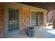 Outdoor patio area featuring brick walls, two large windows, and an air conditioning unit at 3091 Colonial Way # C1, Atlanta, GA 30341