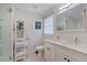 Bright bathroom with double vanity, a framed mirror, shower with glass doors, and white shelving at 1119 Oakdale Se Dr, Smyrna, GA 30080