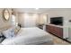 Bright, neutral main bedroom featuring a white-patterned comforter, a dark wood dresser with flat screen tv, and a work area at 1119 Oakdale Se Dr, Smyrna, GA 30080