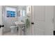 Quaint powder room featuring a pedestal sink, framed window, and a green towel at 1119 Oakdale Se Dr, Smyrna, GA 30080