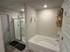 Bright bathroom featuring a soaking tub and glass-enclosed shower with tiled walls at 3306 Loblolly Pine Way, Decatur, GA 30034