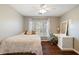 Cozy bedroom featuring a ceiling fan, wood floors, and natural light from the window with decorative curtains at 5073 Kingsbridge Pass, Powder Springs, GA 30127