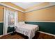 Cozy bedroom with natural light, wainscoting, and wood-look flooring at 5073 Kingsbridge Pass, Powder Springs, GA 30127