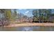 Scenic view of lake with fountain and tree-lined path, enhancing the community's natural beauty at 5073 Kingsbridge Pass, Powder Springs, GA 30127