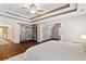 Main bedroom with a tray ceiling, wood floors, sitting area, and bookshelf at 5073 Kingsbridge Pass, Powder Springs, GA 30127