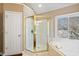 Elegant bathroom featuring a glass-enclosed shower and a soaking tub by a window at 5073 Kingsbridge Pass, Powder Springs, GA 30127