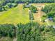 Vibrant aerial shot of the property with lush trees, green fields, and surrounding woods at 1820 Walker Sw Rd, Conyers, GA 30094