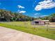 Exterior view of a pristine white barn with fenced pasture, surrounded by lush trees and green fields at 1820 Walker Sw Rd, Conyers, GA 30094