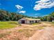 Exterior shot of a well-kept white barn with multiple stalls, set against a backdrop of lush trees at 1820 Walker Sw Rd, Conyers, GA 30094