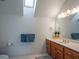 Bathroom with a wooden vanity, white countertop, a mirror, and a bright skylight at 1820 Walker Sw Rd, Conyers, GA 30094