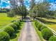 Scenic driveway lined with trees and white fencing leads through the lush green landscape at 1820 Walker Sw Rd, Conyers, GA 30094