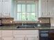 Kitchen close-up featuring a window over the sink, and white cabinets with granite countertops at 1820 Walker Sw Rd, Conyers, GA 30094