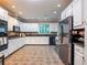 Full kitchen view showcasing tile flooring, stainless steel appliances and white cabinets at 1820 Walker Sw Rd, Conyers, GA 30094