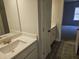 Bathroom with a double vanity, stone countertop, grey tiled flooring, and a view of the bedroom at 3292 Lions Ruby Ln, Atlanta, GA 30349