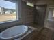 Gorgeous bathroom featuring soaking tub and walk-in shower with stylish gray tile at 3292 Lions Ruby Ln, Atlanta, GA 30349