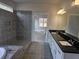 Main bathroom featuring double sinks with black countertop, tiled shower, and bathtub at 3292 Lions Ruby Ln, Atlanta, GA 30349