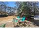 Backyard patio area with a glass table and blue patio chairs, plus a grill at 3377 Fielders Point, Dacula, GA 30019