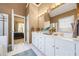 Main bathroom features a double sink, white cabinets, a large mirror, and gold fixtures at 3377 Fielders Pt, Dacula, GA 30019