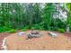 Stone fire pit surrounded by landscaping in wooded area at 601 Cork St, Woodstock, GA 30188