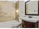 Bathroom featuring a shower-tub combo with brown tile surround, vanity with storage, and decorative framed mirror at 601 Formwalt Sw St, Atlanta, GA 30312