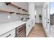 Modern wet bar with white cabinets, floating shelves and wine cooler at 1076 Brookglynn Trce, Decatur, GA 30032