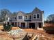 New construction townhomes featuring gray and white siding, double-hung windows, and a one-car garage at 11616 E Lovejoy Rd, Hampton, GA 30228