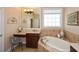 Elegant bathroom featuring a soaking tub, makeup vanity, and natural light from a window at 221 Aster Ct, Canton, GA 30114