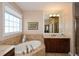 Bright bathroom with a garden tub, tile surround, and a large mirror over a vanity at 221 Aster Ct, Canton, GA 30114