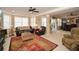 Open-concept living room with fireplace, large windows, ceiling fan, and carpet floors at 221 Aster Ct, Canton, GA 30114