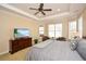 A bright main bedroom offers a comfortable bed, multiple windows, and a television at 221 Aster Ct, Canton, GA 30114