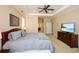Comfortable main bedroom with a tray ceiling, fan, and television on a wooden dresser at 221 Aster Ct, Canton, GA 30114