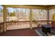 Covered back porch overlooking wooded backyard with railing and outdoor seating area at 221 Aster Ct, Canton, GA 30114