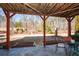 Covered outdoor patio with wooded views and a table and chairs for outdoor entertaining at 221 Aster Ct, Canton, GA 30114