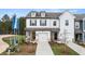 Inviting townhome featuring white siding, black shutters, attached garage, and a landscaped front yard at 281 Kenoot Dr # 36, Mcdonough, GA 30253