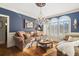 Formal living room with hardwood floors, plantation shutters, and a decorative chandelier at 580 Meadows Creek Dr, Johns Creek, GA 30005