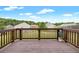 Outdoor wooden deck area with railing, potted plant, and a view of trees and other homes at 11119 Torino Dr, Hampton, GA 30228