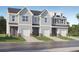 Three-unit townhome building with gray siding, white garage doors, and landscaping at 261 Kenoot Dr # 41, Mcdonough, GA 30253