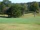 Scenic golf course with well-maintained green, mature trees and golfer at 410 Candler Park Ne Dr # C-1, Atlanta, GA 30307