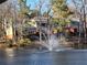 Beautiful waterfront condo building overlooking lake with fountain and trees at 54 Basswood Cir, Atlanta, GA 30328