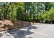 Parking lot with basketball hoop surrounded by dense forest at 54 Basswood Cir, Atlanta, GA 30328