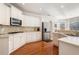 White kitchen with stainless steel appliances and hardwood floors at 179 Waterstone Pt, Acworth, GA 30101