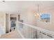 Upstairs hallway with chandelier and view to entry at 179 Waterstone Pt, Acworth, GA 30101