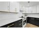 Eat-in kitchen with white subway tile, stainless steel appliances, and white and dark cabinetry at 693 Peyton Sw Rd, Atlanta, GA 30311